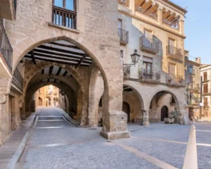 Plaza porticada de Calaceite con arcos de piedra y edificios históricos en el Matarraña
