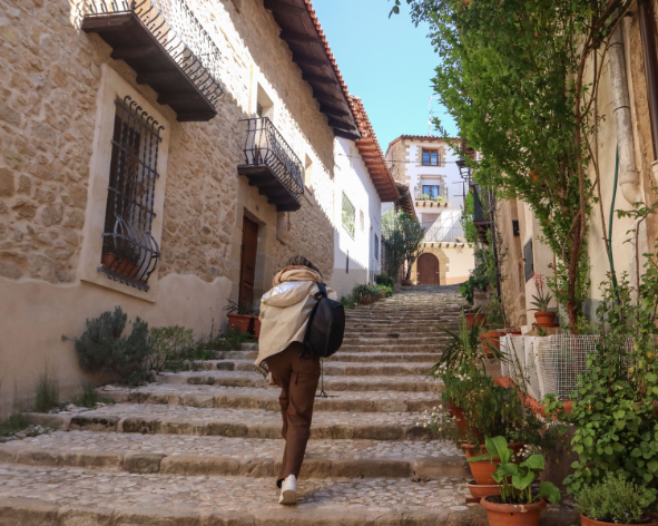 Persona paseando por las calles de piedra del casco histórico de Valderrobres en el Matarraña