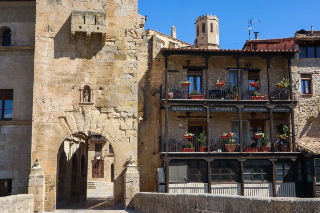 Entrada al casco histórico de Valderrobres a través del Portal de San Roque y el puente de piedra con edificios tradicionales al fondo