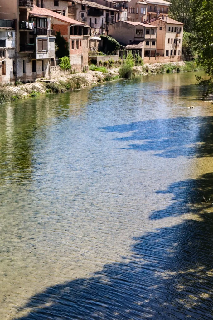 Vista del río Matarraña con casas tradicionales del casco urbano de Valderrobres junto a la orilla en un entorno tranquilo