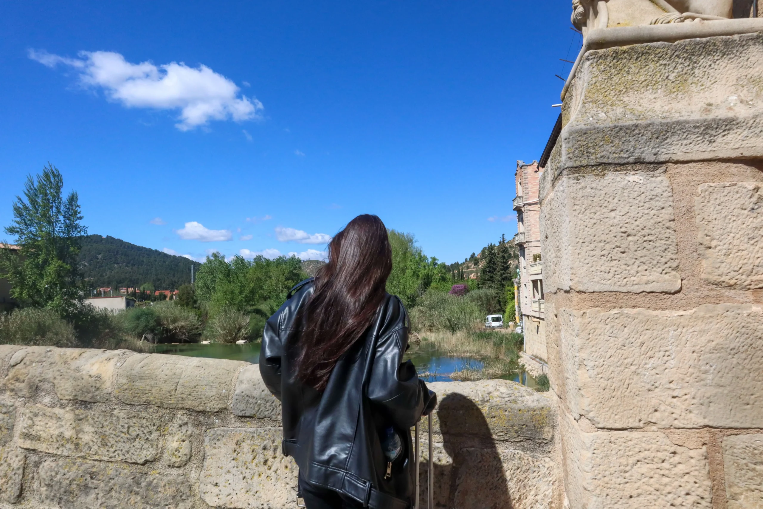 Persona observando el río Matarraña desde el puente de Valderrobres