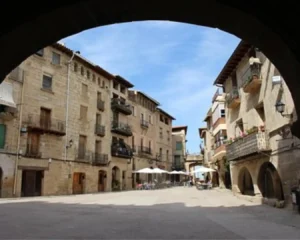 Plaza Mayor de Torre del Compte con soportales y casas de piedra en el Matarraña