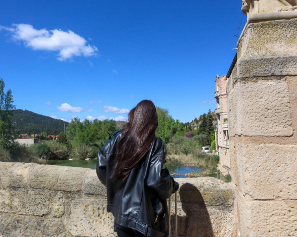 Persona observando el río y el paisaje natural de Valderrobres desde un puente de piedra